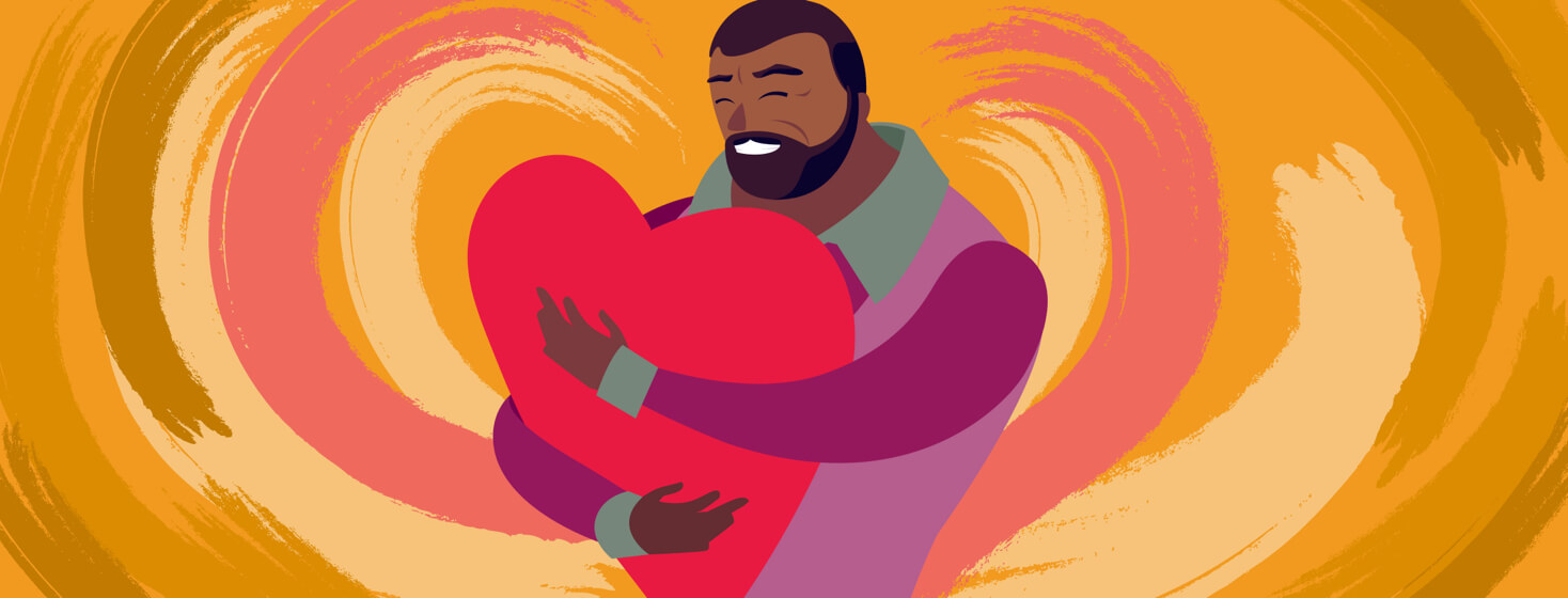 A man is hugging a large heart to his chest.