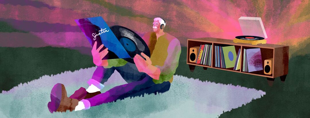 a man sitting on the floor listening to records